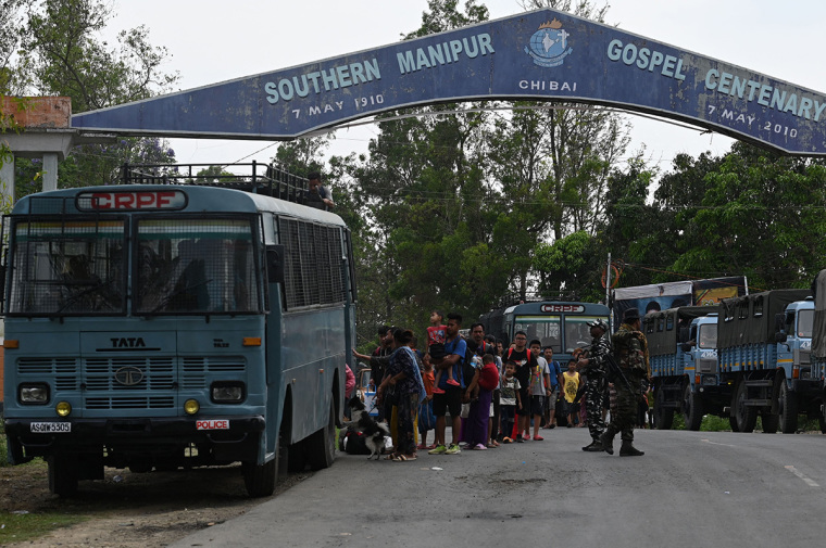 Meitei refugees queue along to board a paramilitary truck at a transit point after being evacuated from the violence that hit Churachandpur, near Imphal in the northeastern Indian state of Manipur on May 9, 2023. More than 50 people have been killed in the hilly border region in clashes between the majority Meitei people, who are mostly Hindus, and the mainly Christian Kuki tribe. Thousands of troops have been deployed to restore order, while around 23,000 residents have fled their homes for the safety of ad-hoc army-run camps for the displaced. (Photo by Arun SANKAR / AFP) (Photo by ARUN SANKAR/AFP via Getty Images)