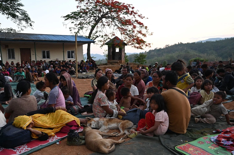 As pessoas esperam em um abrigo temporário em um campo militar, depois de serem evacuadas pelo exército indiano, enquanto fogem da violência étnica que atingiu o estado de Manipur, no nordeste da Índia, em 7 de maio de 2023. Cerca pessoas fugiram da violência étnica no nordeste da Índia, que teria matado pelo menos 54, disse o Exército em 7 de maio de 2023, embora não tenha havido nova "grande violência" durante a noite. de 23.000 | ARUN SANKAR/AFP via Getty Images