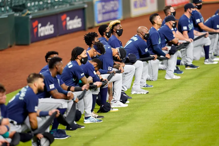 Jogadores do Seattle Mariners se ajoelham por justiça social antes de um jogo de beisebol contra o Houston Astros na sexta-feira, 24 de julho de 2020, em Houston.
David J. Phillip, AP